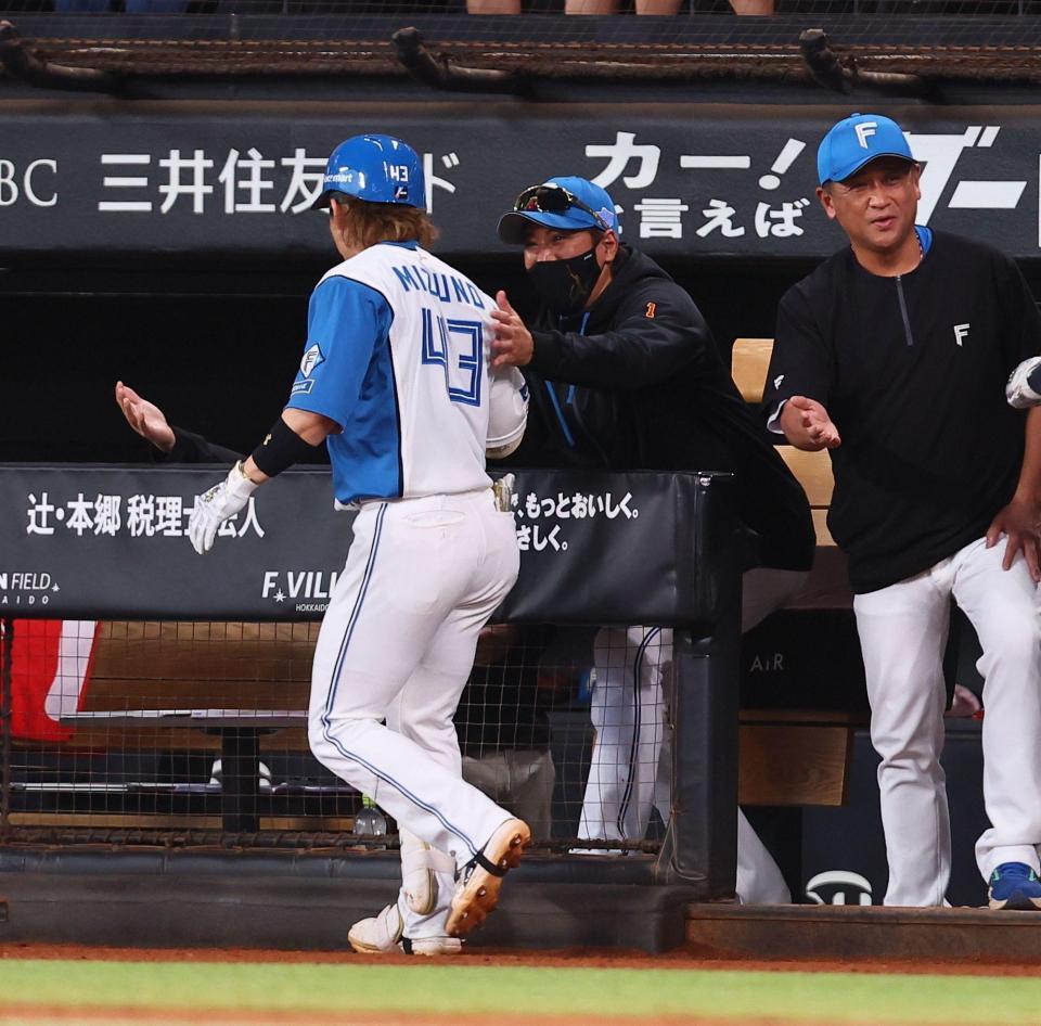 ７回、逆転満塁本塁打を放った水野（左）を迎える新庄監督（中央）＝撮影・中島達哉