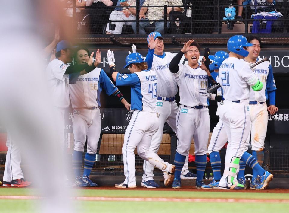 ７回、逆転満塁本塁打を放ち、ナインに迎えられる水野（中央）＝撮影・中島達哉