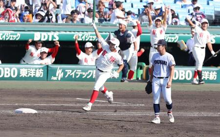 ３回、ライトへ勝ち越し３ランを放ち、歓喜に沸くナインを背に腕を突き上げる智弁和歌山・楠本龍生（撮影・中田匡峻）