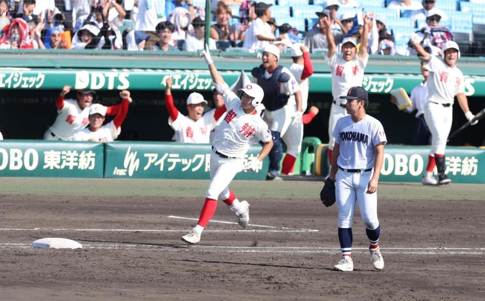 ３回、ライトへ勝ち越し３ランを放ち、歓喜に沸くナインを背に腕を突き上げる智弁和歌山・楠本龍生（撮影・中田匡峻）