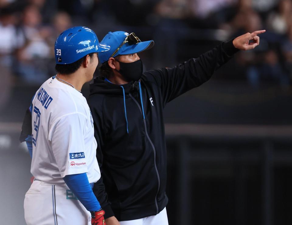 ３回、レイエスが放った適時二塁打の打球の場所を有薗直輝（左）に説明する新庄監督（撮影・中島達哉）