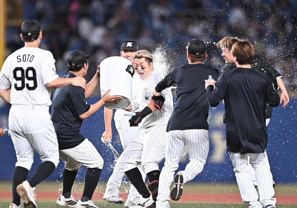 １０回、サヨナラの中越え適時二塁打を放ちナインから手洗い祝福を受ける山口（中央）＝撮影・開出牧）