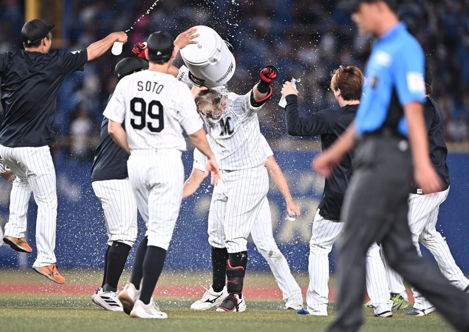 １０回、サヨナラの中越え適時二塁打を放ちナインから手洗い祝福を受ける山口（中央）＝撮影・開出牧