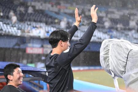 試合中止が発表され、雨の中で待ち続けたスタンドのファンに手を振る西川。左は寺地（撮影・開出牧）