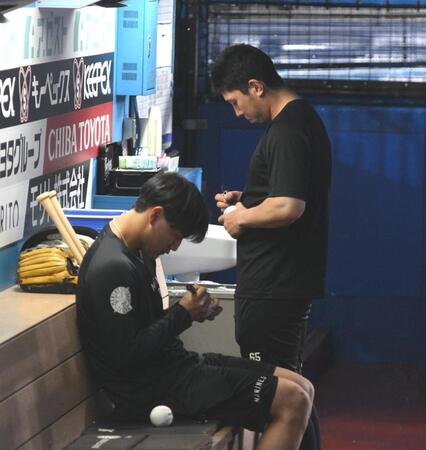 試合中止となりベンチでサインボールにペンを走らせる西川（手前）と寺地（撮影・開出牧）