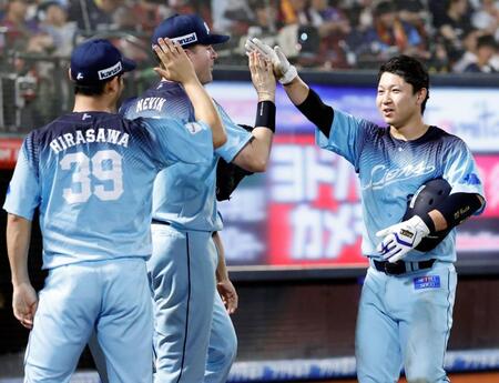 ８回、決勝の２点二塁打を放ち、ナインに迎えられる古賀悠（右）