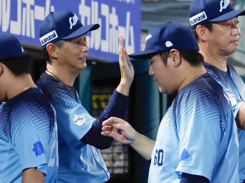楽天に勝利し、中村剛（手前右）らを迎える西口監督（左）