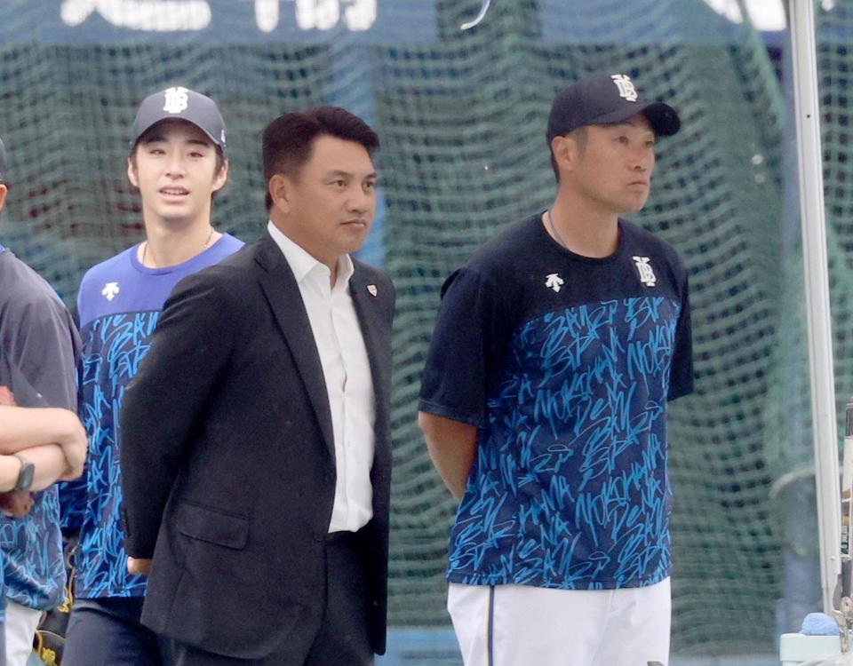 ＤｅＮＡの練習を並んで見る、日本代表の井口監督（左）と相川監督。後方は度会
