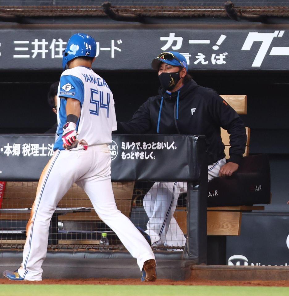 ７回、水谷の勝ち越し打で生還した山県（左）を迎える新庄監督（撮影・中島達哉）