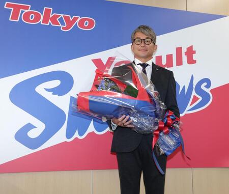 会見の後、花束を手にするヤクルト・石川雅規＝東京都港区の球団事務所（撮影・西岡正）