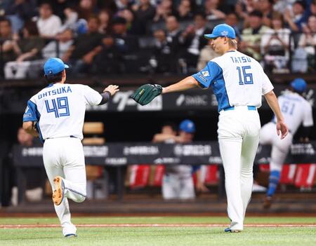 ８回、三塁のピンチを最少失点でしのぎ、大塚（左）を迎える達（撮影・中島達哉）