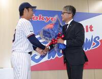 小川（左）から花束を受け取る石川（撮影・西岡正）