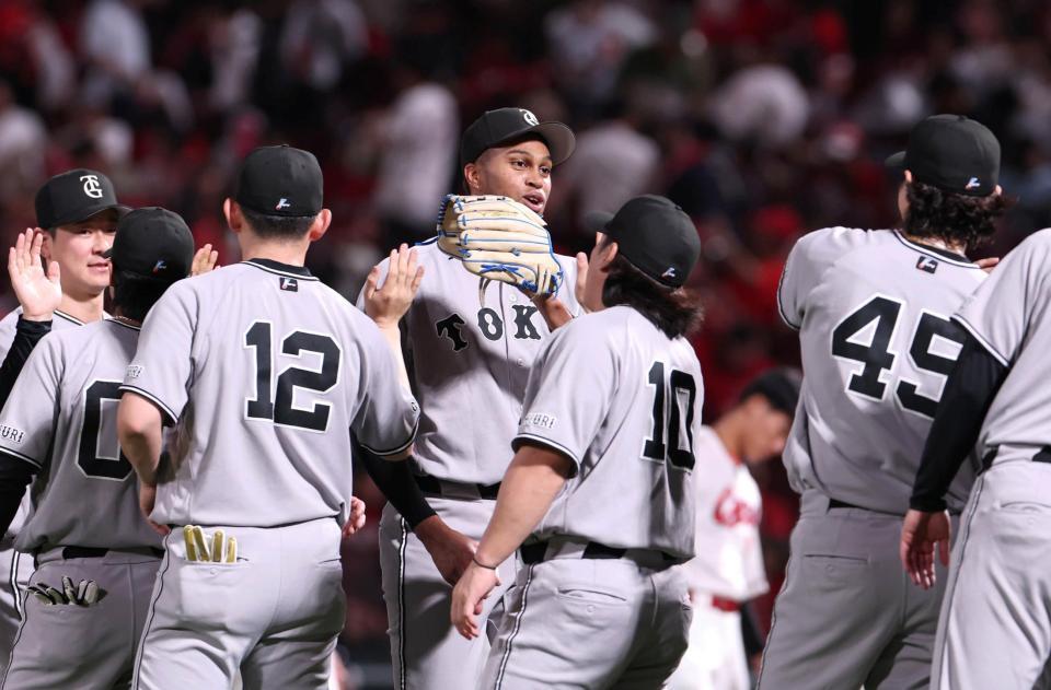 最後を締めたマルティネス（中央）はナインとタッチを交わす（撮影・北村雅宏）