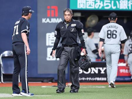 ２回裏のオリックスの攻撃を終え、サブロー監督（８６）と話し、岸田監督（左）の元に向かう白井審判（撮影・中田匡峻）