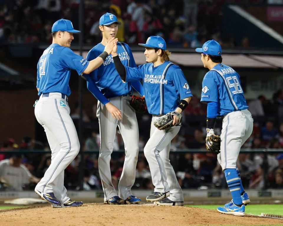 　楽天に勝利し、タッチを交わす清宮幸（左端）ら日本ハムナイン