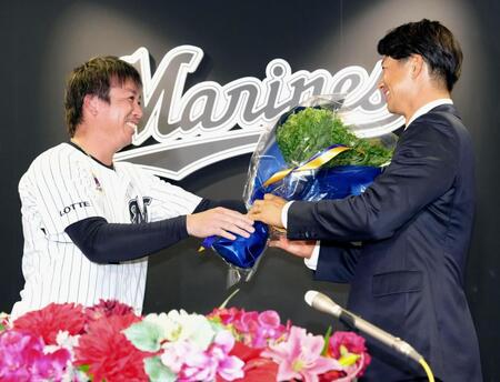 記者会見を終え、益田（左）から花束を受け取る唐川