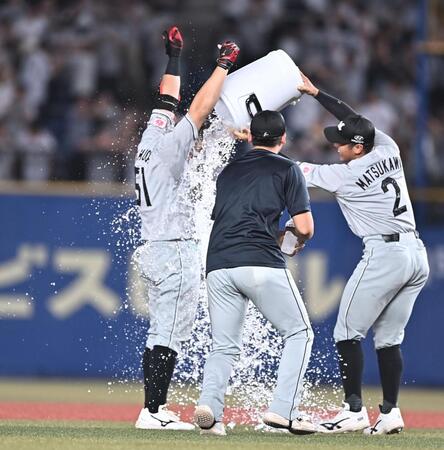 ９回、サヨナラの中越え適時二塁打を放ち手洗い祝福を受ける山口（左）＝撮影・開出牧