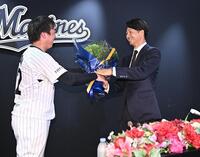 引退会見で益田（左）から花束を受け取り感激の唐川（撮影・開出牧）