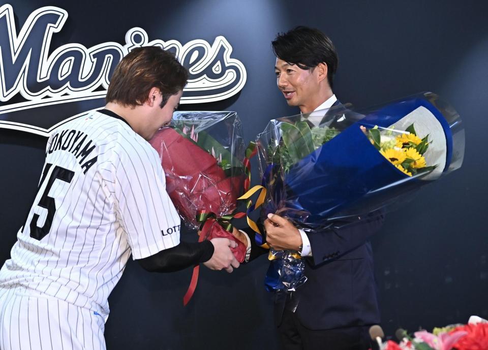 引退会見で横山陸人（左）から花束を受け取り握手を交わすロッテ・唐川侑己＝ＺＯＺＯマリンスタジアム（撮影・開出牧）
