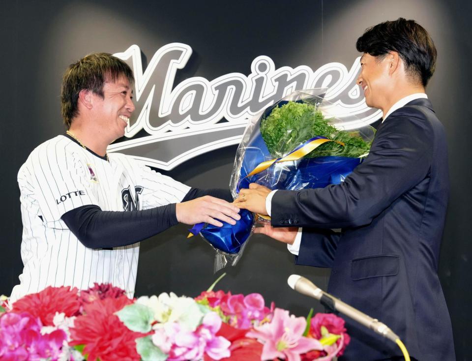 記者会見を終え、益田（左）から花束を受け取る唐川
