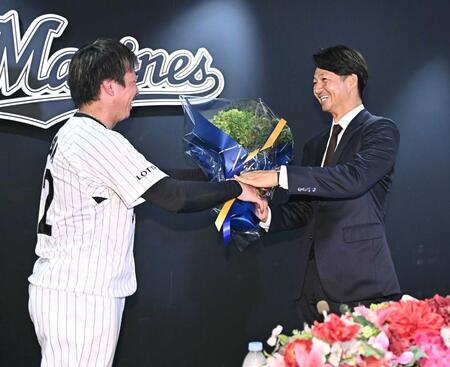 　引退会見後に益田（左）から花束を受け取る唐川（撮影・開出牧）
