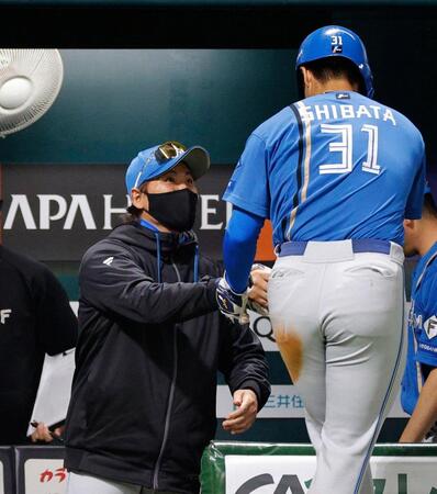 ２回、田宮の二ゴロで生還した三走柴田（手前）を迎える新庄監督