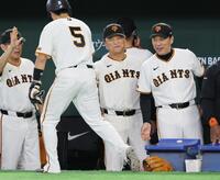 ６回、生還した門脇（５）とタッチを交わす橋上監督代行（中央）