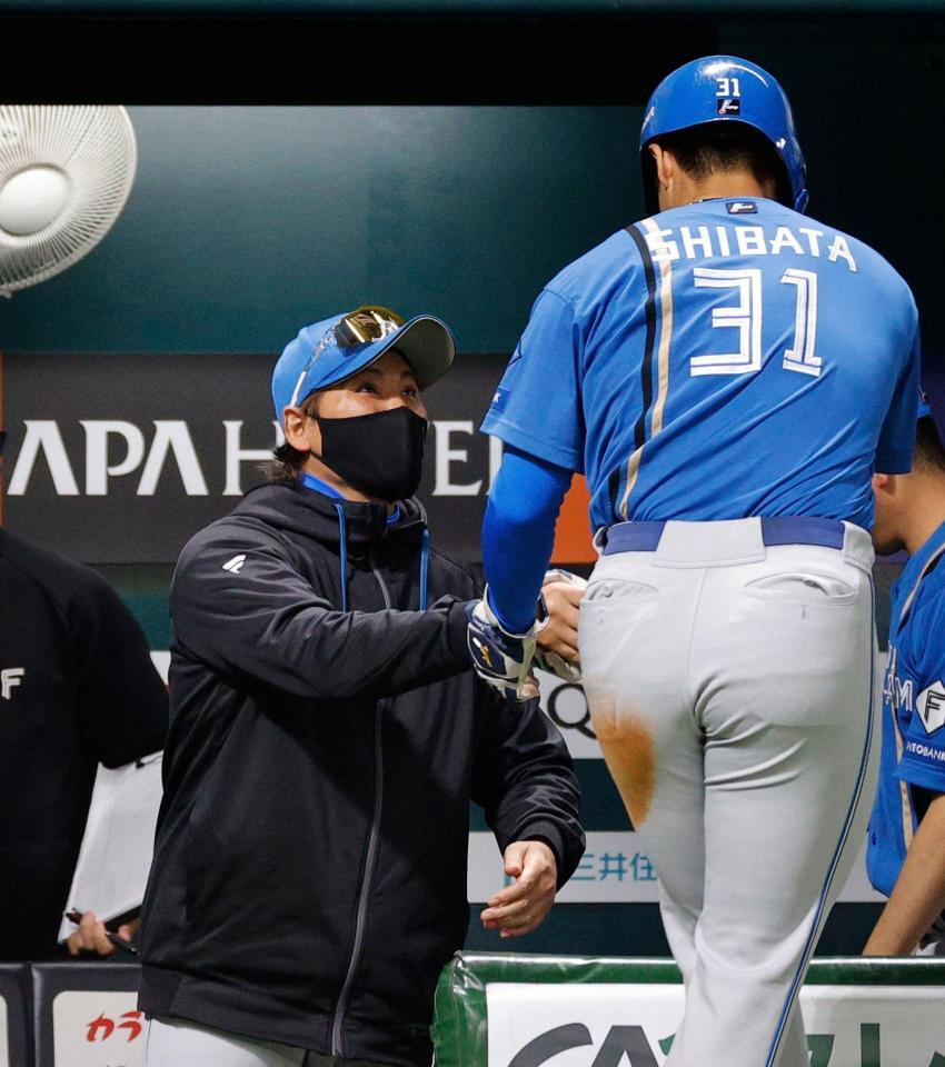 ２回、田宮の二ゴロで生還した三走柴田（手前）を迎える新庄監督
