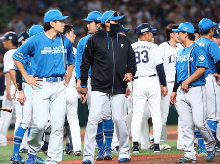 ５回、西武ナインと日本ハムナインがベンチを飛び出す中、輪の中に入って場を収め、ベンチに戻る新庄監督（中央）＝撮影・中島達哉