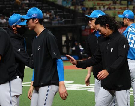 １２回引き分け試合となり、伊藤（右）を迎える新庄監督（撮影・中島達哉）