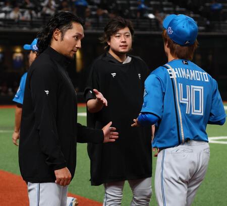 １２回引き分け試合となり、中継ぎ陣を迎える伊藤（左）＝撮影・中島達哉