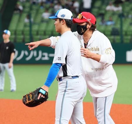 試合前、ファーストミットを持った柴田（左）に指導する新庄監督（撮影・中島達哉）