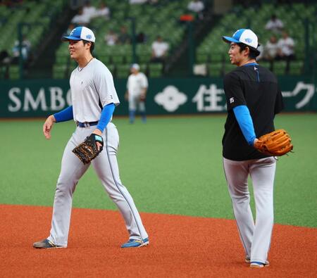 試合前、谷内内野守備走塁コーチ（右）の指導の下、一塁でノックを受ける柴田（撮影・中島達哉）