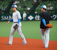 試合前、谷内内野守備走塁コーチ（右）の指導の下、一塁でノックを受ける柴田（撮影・中島達哉）