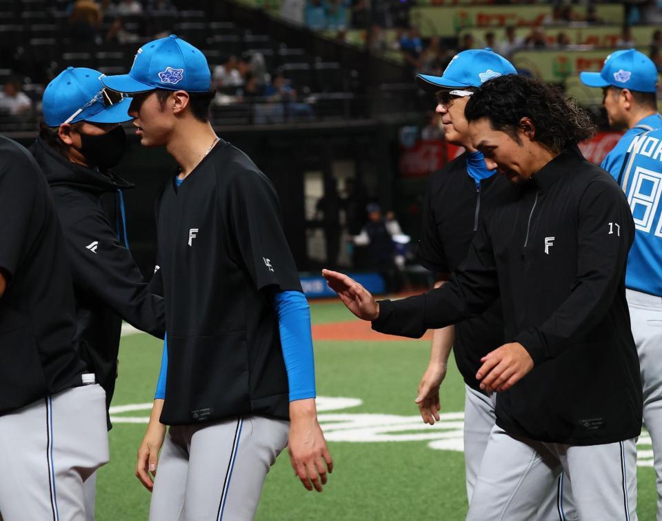 １２回引き分け試合となり、伊藤（右）を迎える新庄監督（撮影・中島達哉）