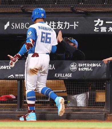 ８回、同点ソロを放った万波（左）を手を合わせて迎える新庄監督（撮影・中島達哉）