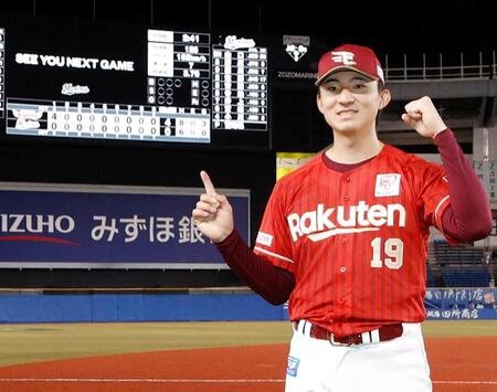 　完封で８勝目を挙げスコアボードを指さす荘司