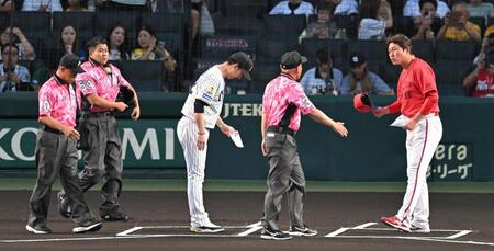 メンバー表を交換する新井監督と藤川監督（撮影・飯室逸平）
