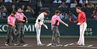 メンバー表を交換する新井監督と藤川監督（撮影・飯室逸平）