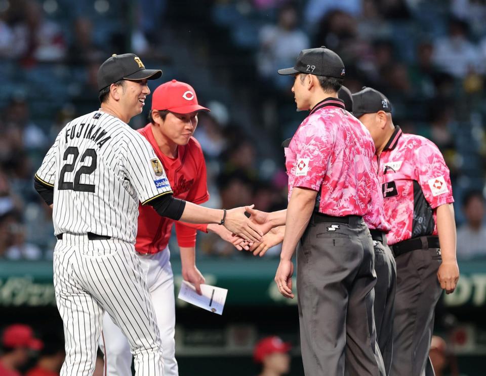 新井監督とメンバー表を交換し審判団と笑顔で握手を交わす藤川監督（撮影・山口登）