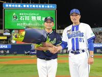 相川監督（右）から花束を受け取り、握手する石川（撮影・西岡正）
