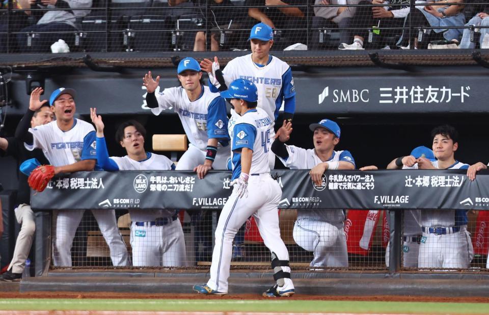 ５回、勝ち越しソロを放った大塚（中央）を迎える日本ハムナイン（撮影・中島達哉）