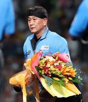 公式戦通算２０００試合出場を達成し、花束を受け取る名幸一明審判員（撮影・西田忠信）