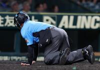 ８回、ワンバウンドしたボールが直撃し、倒れ込む名幸一明球審（撮影・西田忠信）