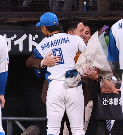 シートノック後、中島（左）に花束を贈り、抱き合う杉谷氏（撮影・中島達哉）