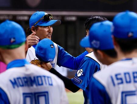 ７回、交代を告げられ、新庄監督（左）に迎えられる中島（撮影・中島達哉）