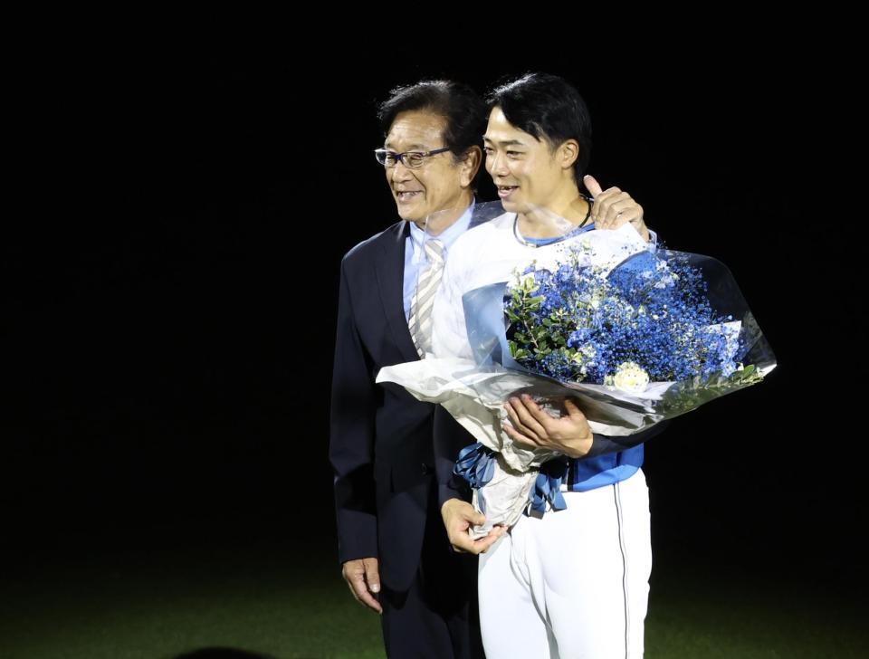 引退セレモニーの花束贈呈で登場した栗山ＣＢＯ（左）と記念撮影する中島（撮影・中島達哉）