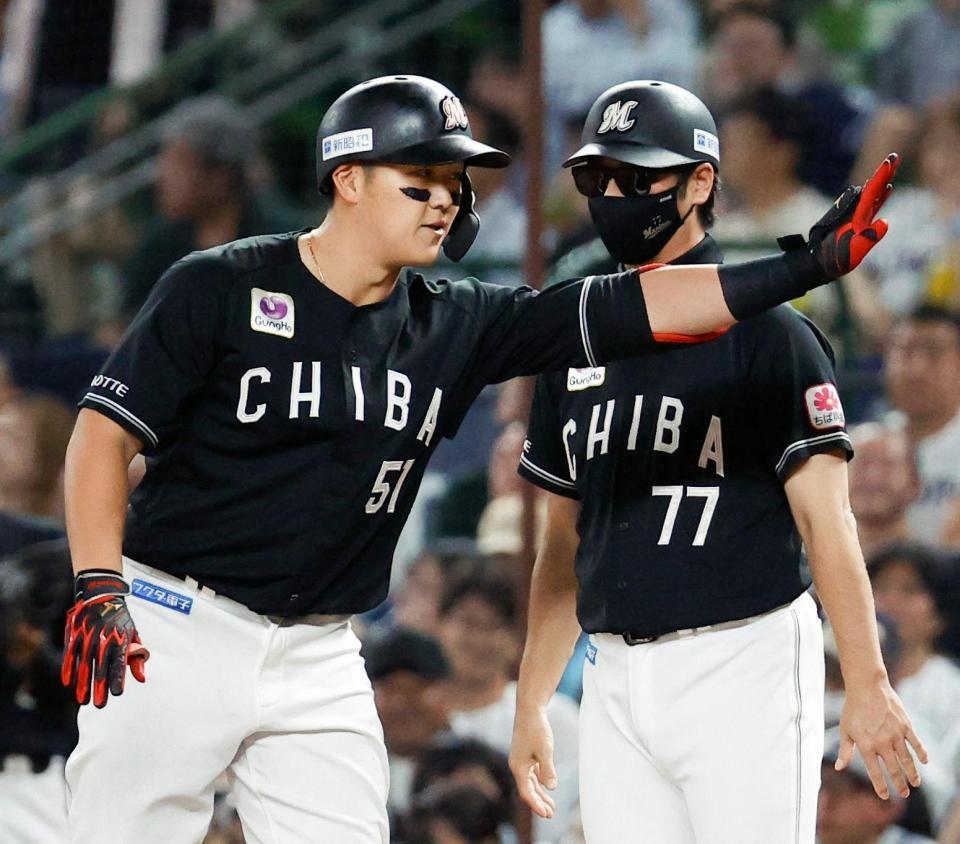 ６回、先制打を放ちベンチに向かって手を振るロッテ・山口（左）