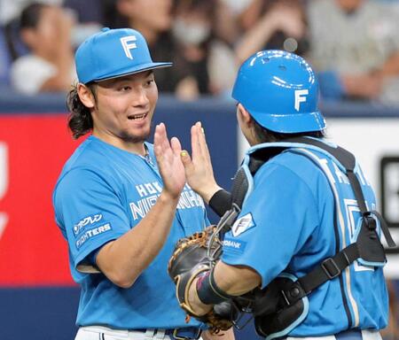 　１０勝目を挙げ田宮（右）とタッチを交わす伊藤（撮影・立川洋一郎）