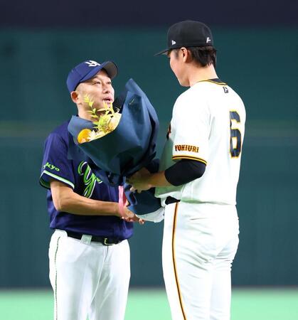 坂本から花束を受け取る石川（左）＝撮影・石井剣太郎